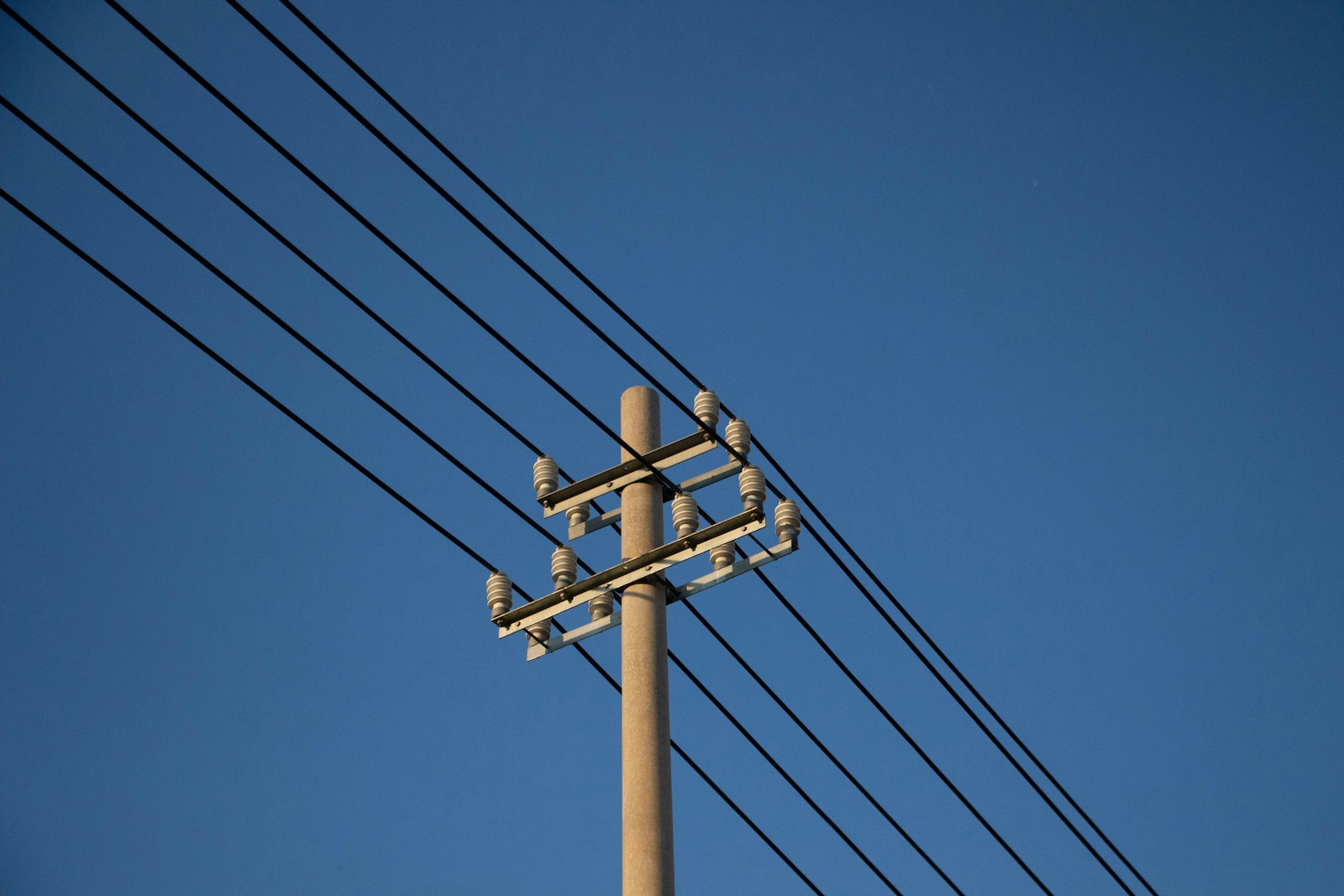 A telephone pole and power lines against a blue sky